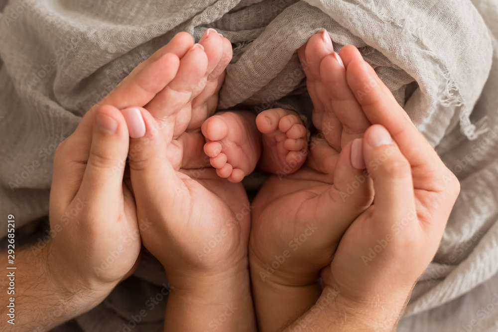 Feet newborn baby in the arms of the mother. feet newborn baby in his hands. baby's feet. baby feet Feet newborn baby in the arms of the mother. feet newborn baby in his hands. baby's feet. baby feet