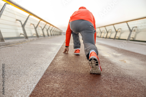 Sprinter standing in a starting position outdoors