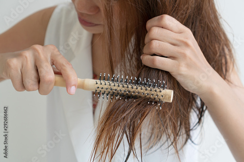 Woman brushing her wet messy hair after bath with comb, Thin hair porblem. Hair Damage, Health And Beauty Concept.