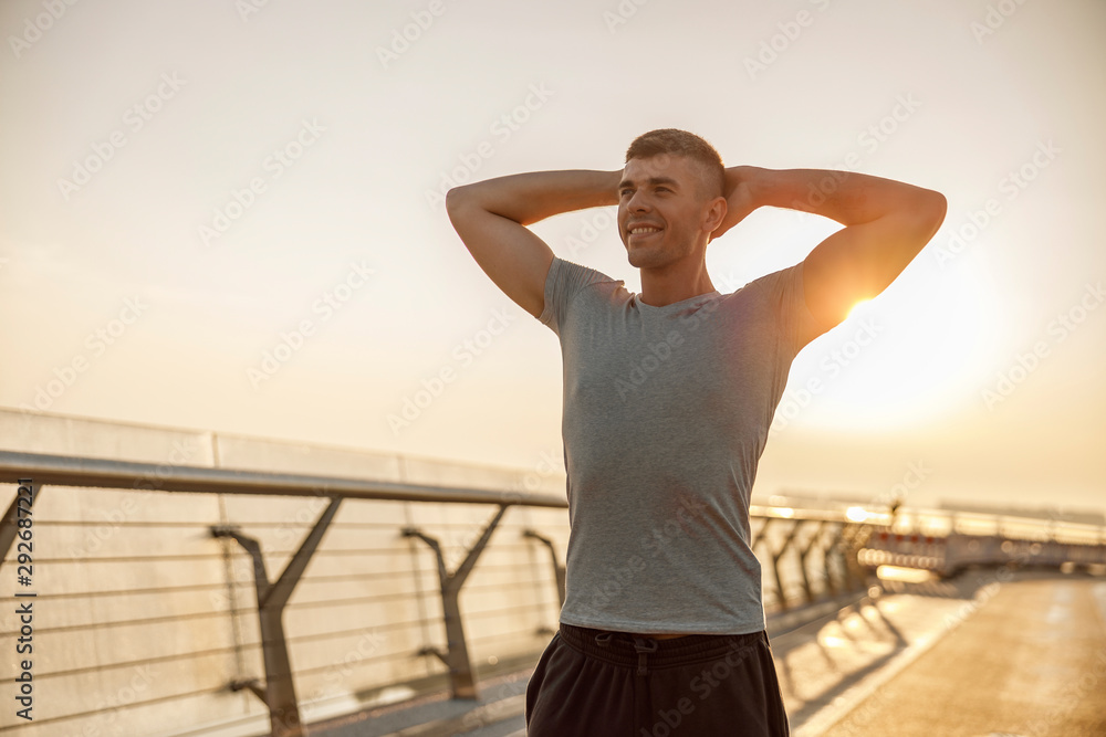 Pleased athlete working out on a bridge