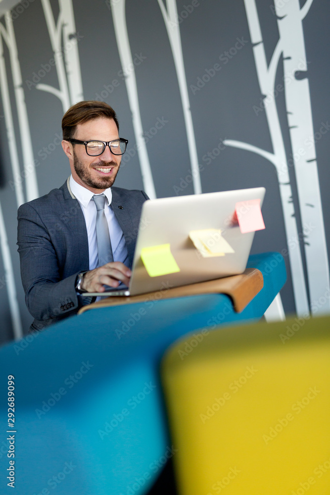 Fototapeta premium Young employee working on computer during working day in office
