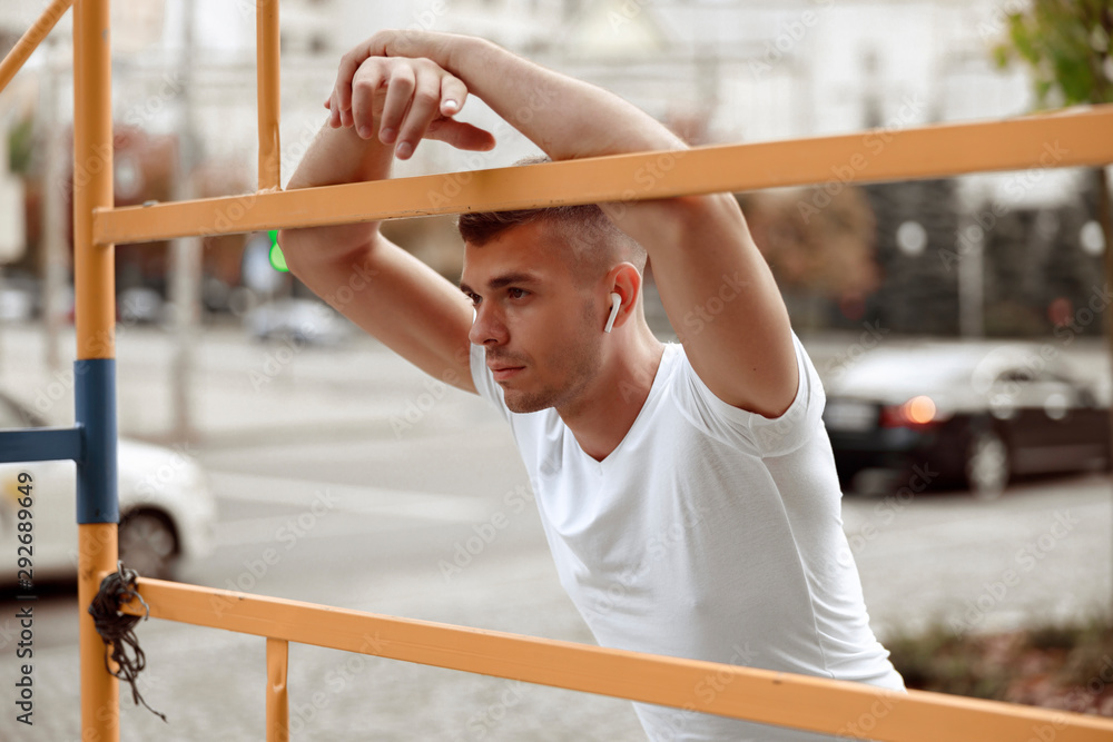 Obraz premium Young man leaning on a metal construction outdoors