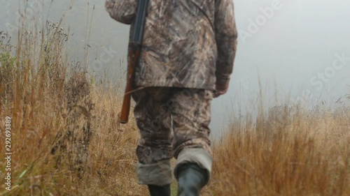 The hunter is on the road. Early morning, fog. Autumn, yellow grass along the road.