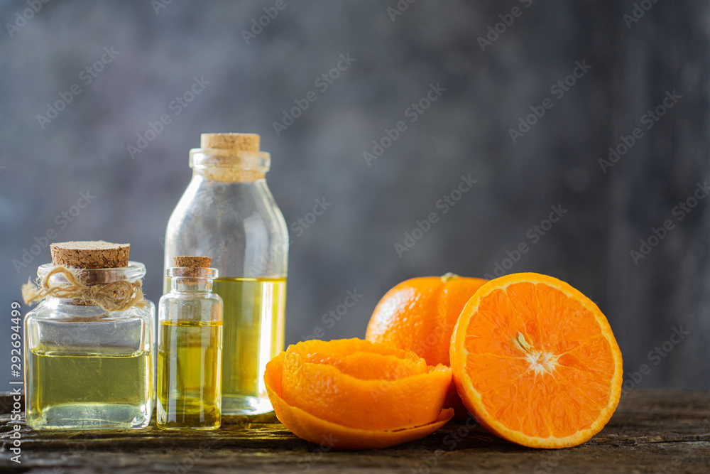 Three bottles with essential oil, orange slice, peel on wooden table.aromatherapy oil natural organic cosmetic. Three bottles with essential oil, orange slice, peel on wooden table.aromatherapy oil natural organic cosmetic.