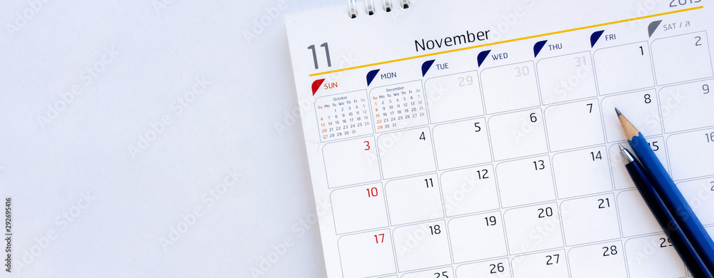 close up calendar in November month schedule with pen and pencil to make appointment meeting or manage timetable each day lay on white background for planning work and life concept close up calendar in November month schedule with pen and pencil to make appointment meeting or manage timetable each day lay on white background for planning work and life concept