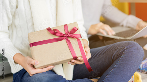 close up young woman holding gift and sit with friends together in living room at house prepare for party merry christmas and happy new year event tonight ,seasonal and festival concept