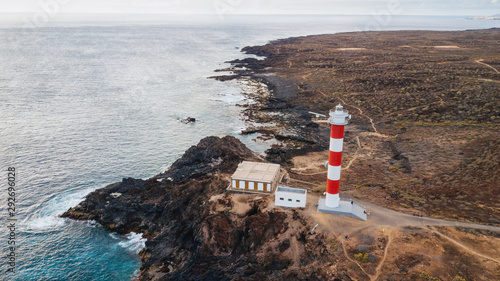 Punta Abona lighthouse. Landscape overlooking the ocean. Sunset. The water is shiny. Aerial. Tenerife Island, Spain