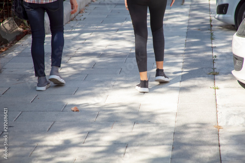 Rear view of a low section of two girls walking