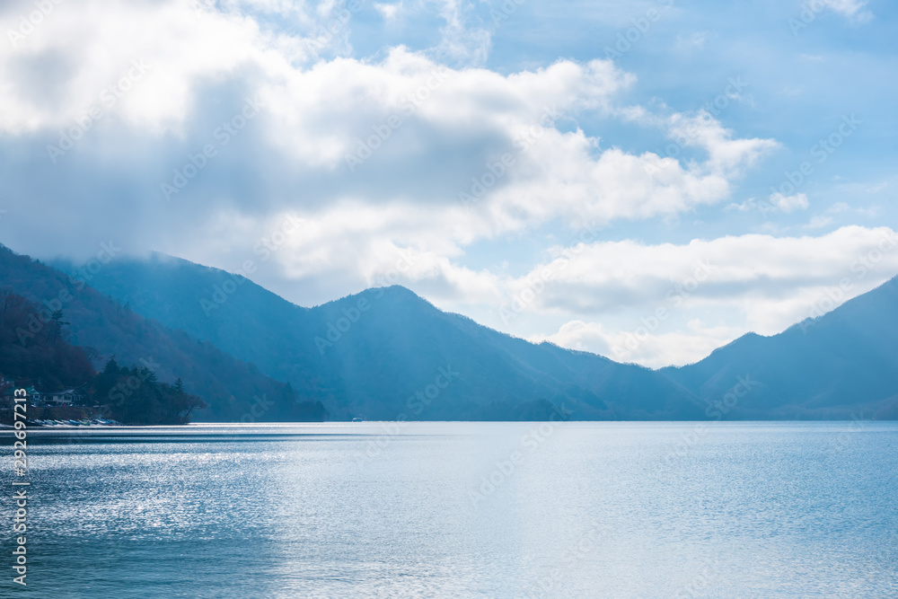 beautiful day landscape of lake Chuzenji with trees, mountains and sun beams near Nikko, Japan, travel background