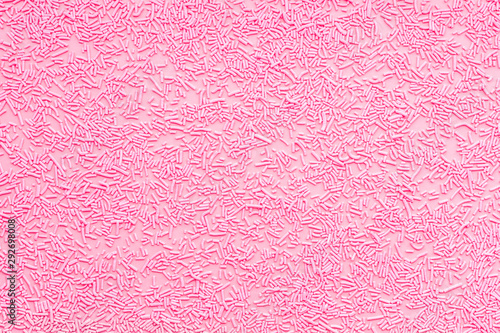 pink sprinkles over pink like background, top view