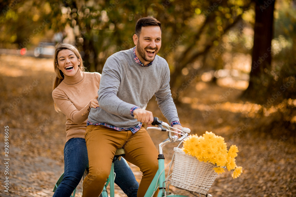 © BGStock72 - Active young couple enjoying together in riding bicycle in golden autumn park