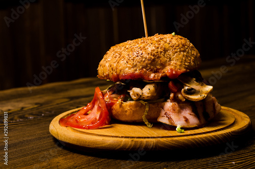 Bacon burger with beef patty on wooden table photo