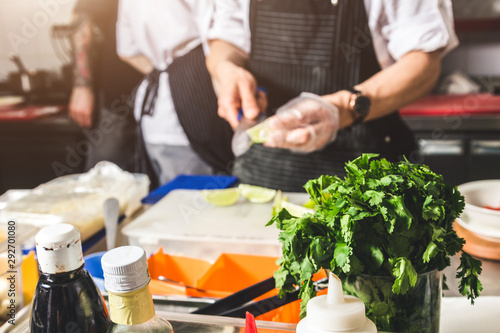 Professional chef cooking in the kitchen restaurant at the hotel, preparing dinner. A cook in an apron makes a salad of vegetables and pizza.