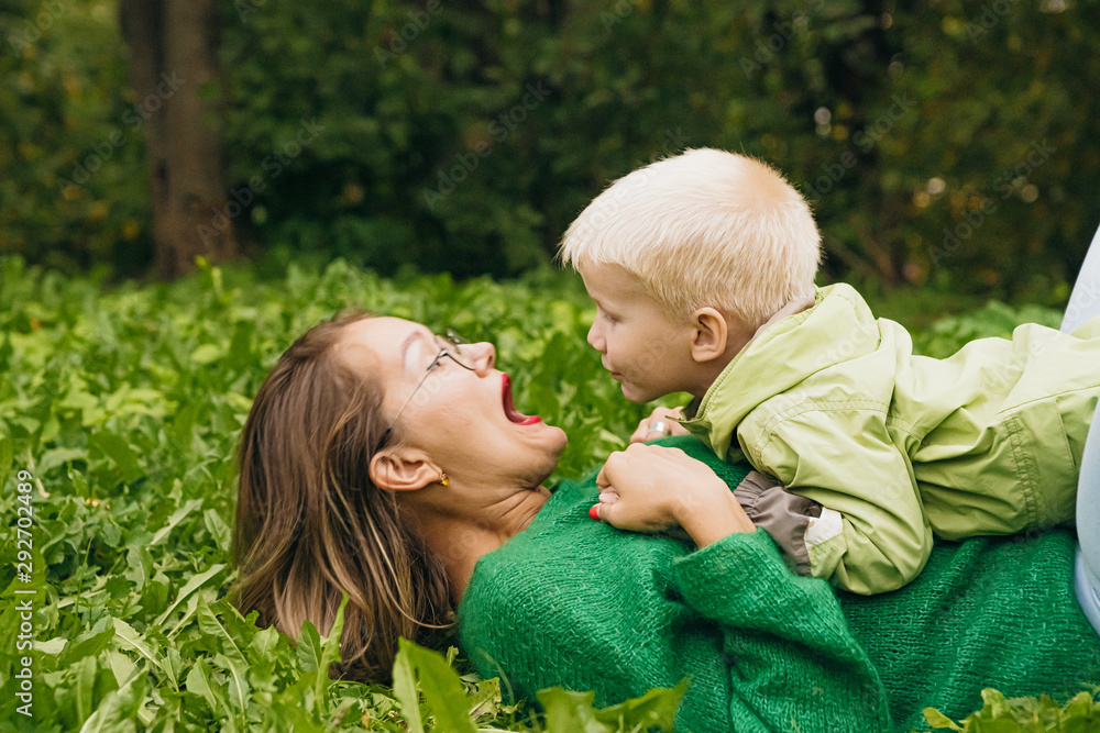Beautiful young mother and her son are playing in the park. mothers Day. love for children. a family Beautiful young mother and her son are playing in the park. mothers Day. love for children. a family