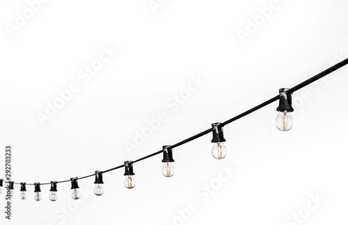 Fotografiet Incandescent bulbs on a black wire on a white background
