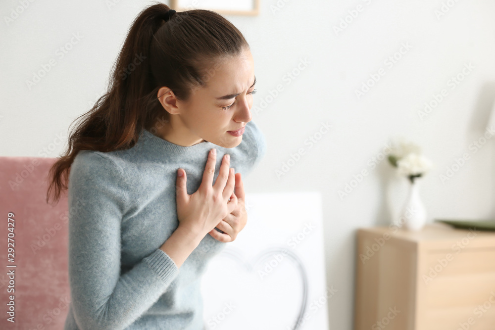 Young woman suffering from heart attack at home Young woman suffering from heart attack at home
