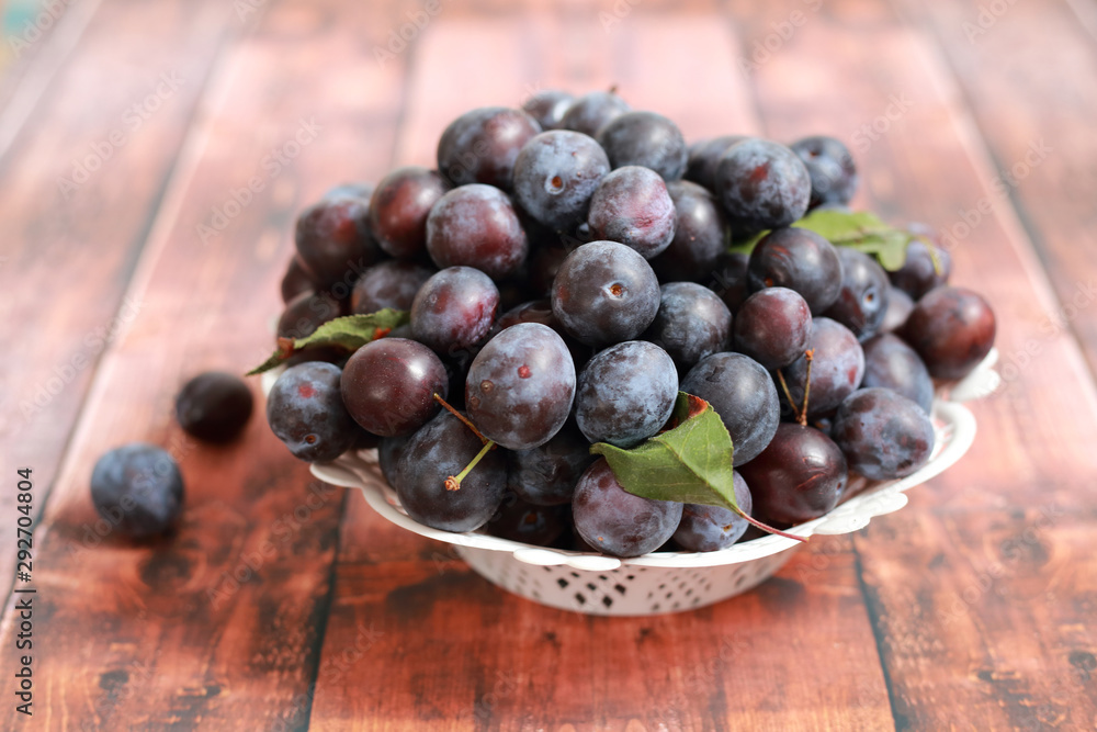 Fototapeta premium blue plums from his garden on a wooden table