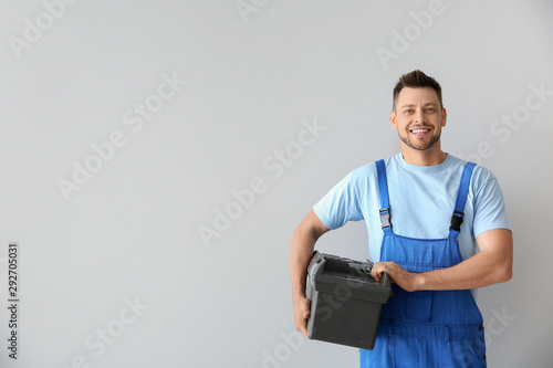Portrait of handsome plumber with tools box on white background photo