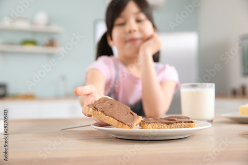 Funny little girl eating ta...