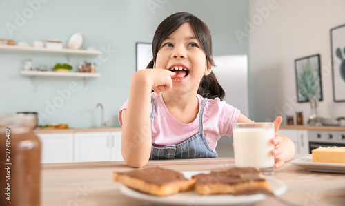 Funny little girl eating ta...