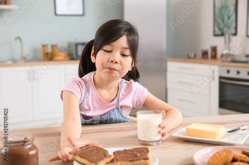 Funny little girl eating ta...