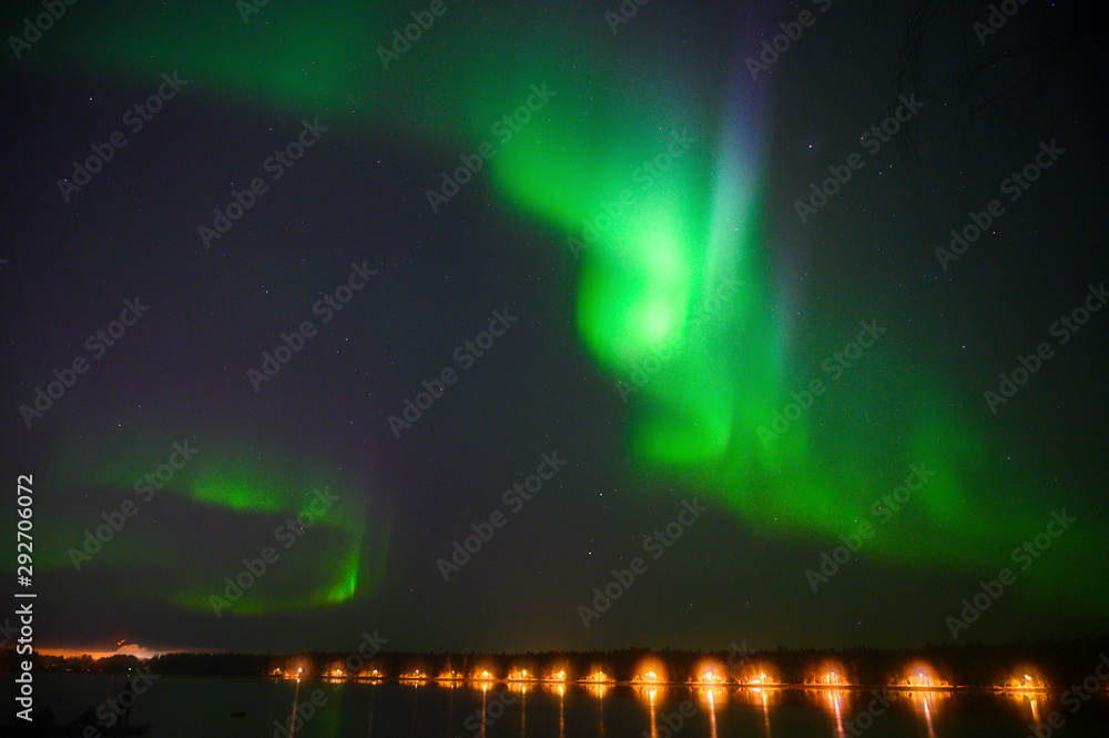 Northern polar light Aurora borealis multicolour light iluminated under the starry dark  sky and water reflection