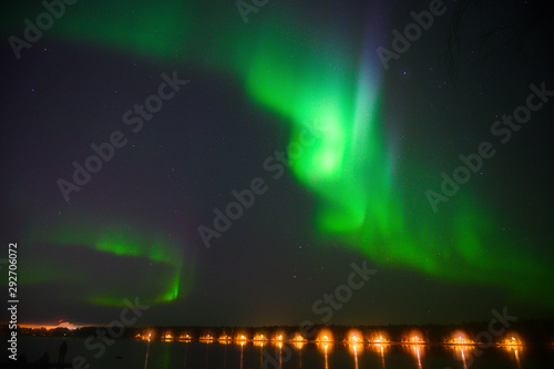 Northern polar light Aurora borealis multicolour light iluminated under the starry dark sky and water reflection