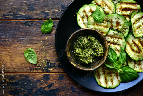 Grilled zucchini slices with basil pesto.Top view with copy space. photo