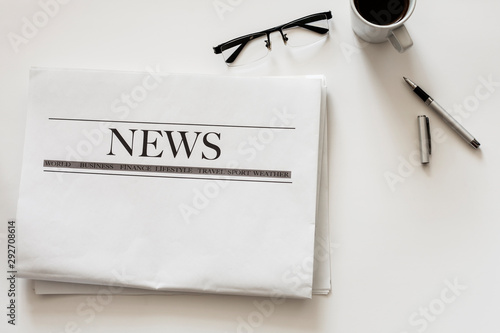 Newspaper and coffee on white background photo