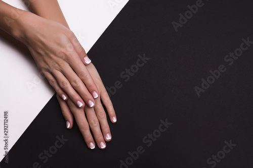 Beautiful hands with french manicure on black background photo