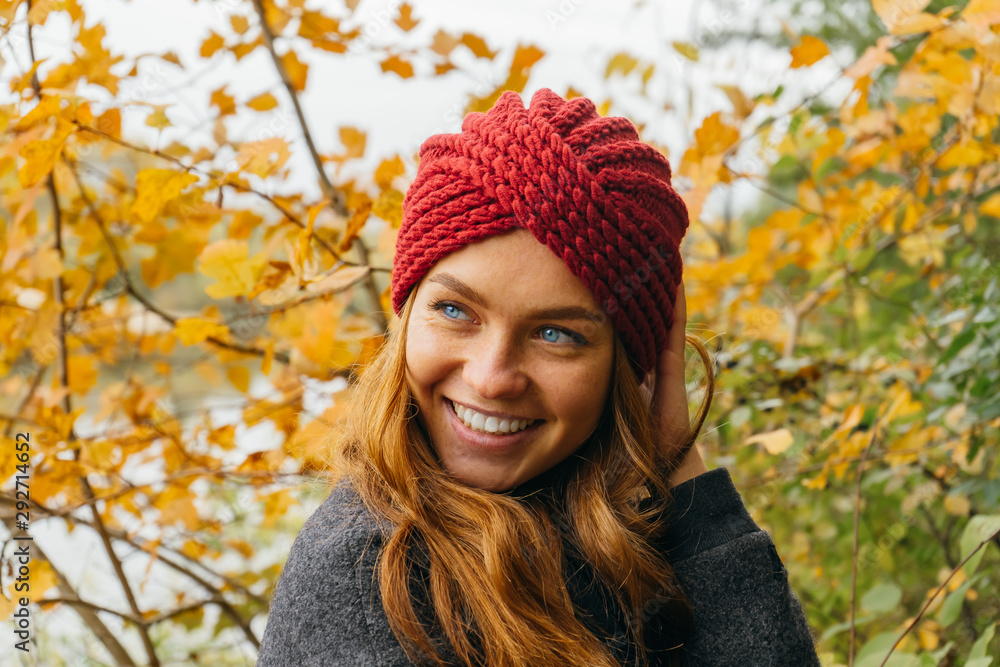 Young happy beautiful girl with red hair in color knitted in an autumn park. Young happy beautiful girl with red hair in color knitted in an autumn park.