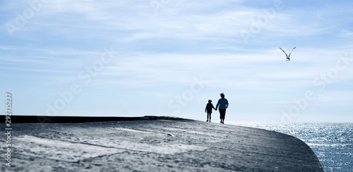 Woman and Child walking on the Cobb, Lyme Regis, Dorset, UK
