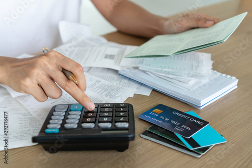 Woman holding saving account passbook and using calculator , account and saving concept.