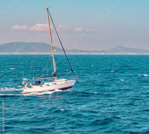 Seascape with sailboat the background of the blue sky.