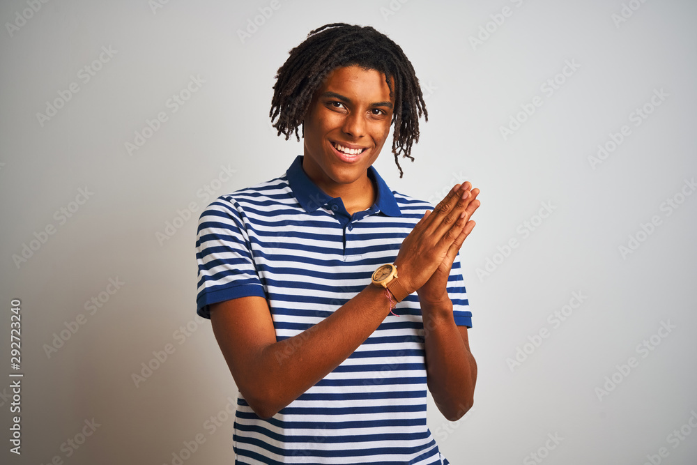 Afro man with dreadlocks wearing striped blue polo standing over isolated white background clapping and applauding happy and joyful, smiling proud hands together Afro man with dreadlocks wearing striped blue polo standing over isolated white background clapping and applauding happy and joyful, smiling proud hands together