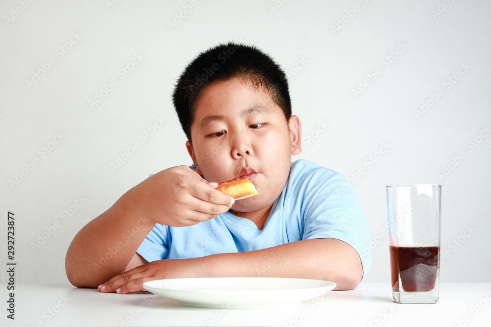 Fat Asian children are eating pizza on a white table with soda nectar. White background. Child weight control concepts