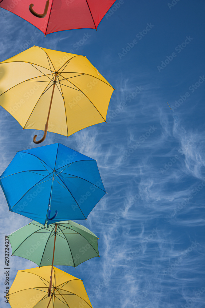 umbrella of different colors floating in the sky, copy-space