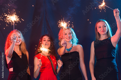 Birthday party, new year and holidays concept - Group of female friends celebrating holding sparklers