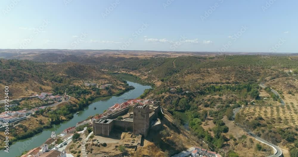 Aerial view of the town of Mertola in southeastern Portuguese Alentejo destination region, located in the margin of Guadiana River, whit its medieval castle, located on the highest point. Portugal. Aerial view of the town of Mertola in southeastern Portuguese Alentejo destination region, located in the margin of Guadiana River, whit its medieval castle, located on the highest point. Portugal.