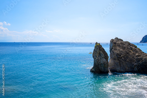 Big stones, blue sea and yellow boat photo