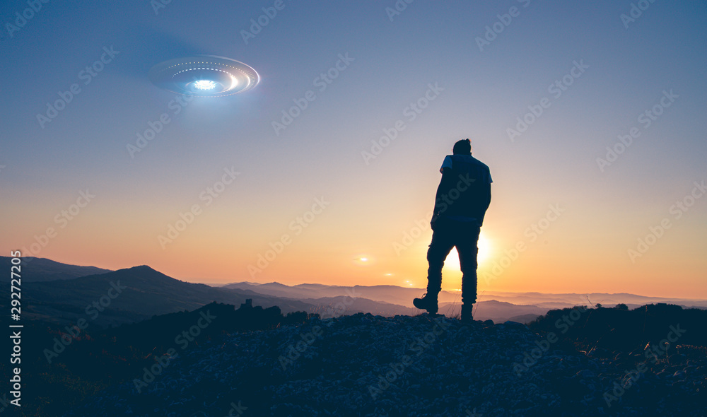 silhouette in a colorful sunrise and some Flying saucer in the sky -photomaniupulation and 3D rendering