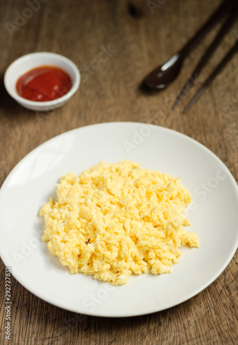 Scramble on a white plate with spoon and chopsticks,ketchup bowl