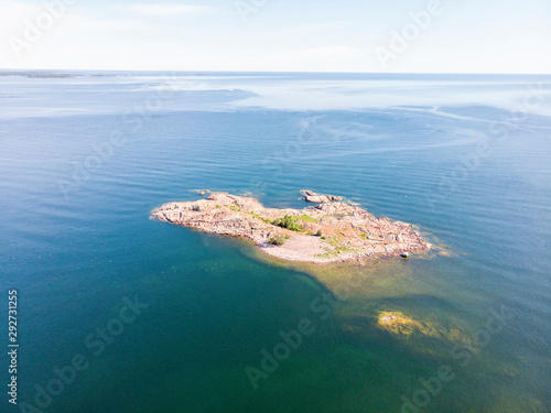 Small islet made of rocks and some trees from high altitude, calm sea and horizon a sunny summer day © hans_chr