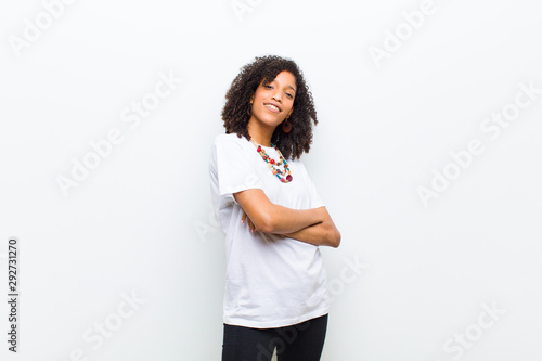 young cool african american woman laughing happily with arms crossed, with a relaxed, positive and satisfied pose photo