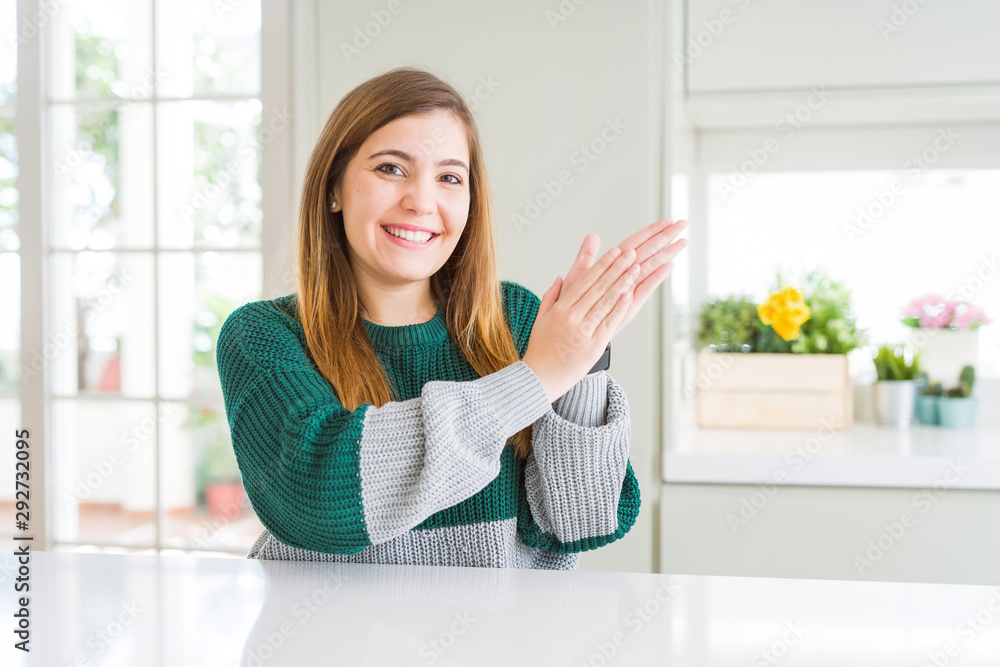 Young beautiful plus size woman wearing casual striped sweater clapping and applauding happy and joyful, smiling proud hands together Young beautiful plus size woman wearing casual striped sweater clapping and applauding happy and joyful, smiling proud hands together