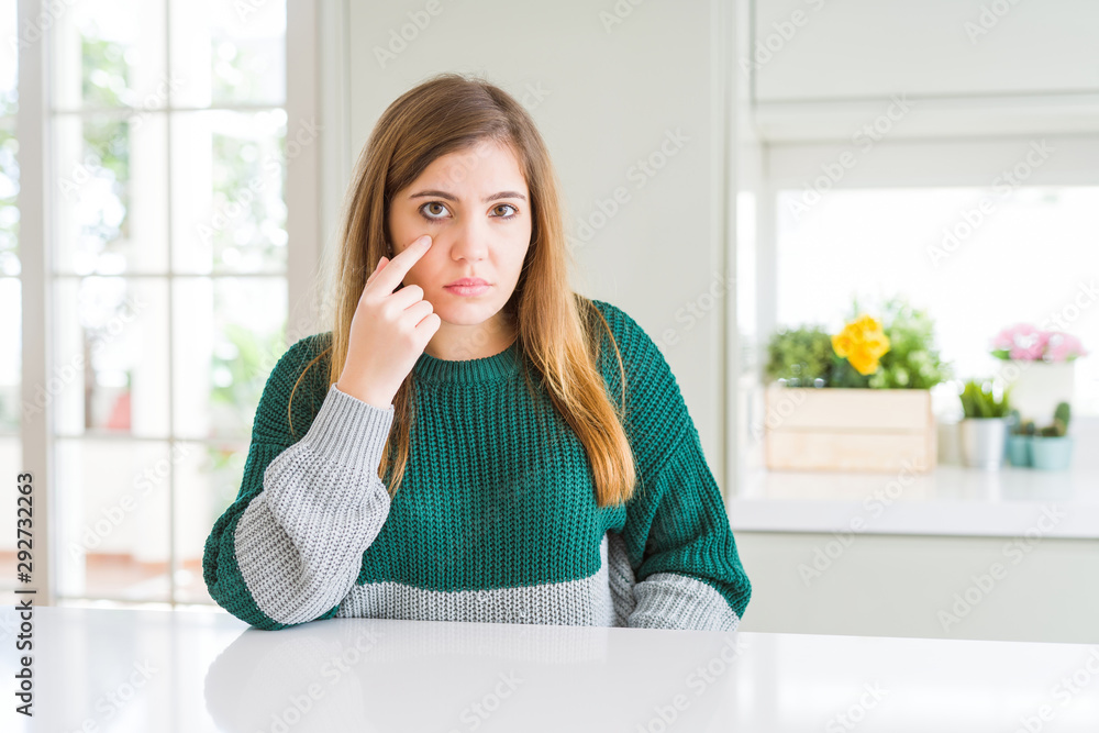 Young beautiful plus size woman wearing casual striped sweater Pointing to the eye watching you gesture, suspicious expression Young beautiful plus size woman wearing casual striped sweater Pointing to the eye watching you gesture, suspicious expression