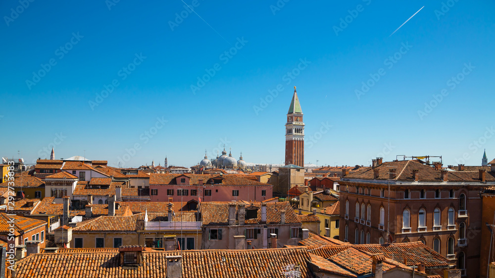 Panoramic view from the top of the spiral staircase at Palazzo Contarini del Bovolo, Venice (Venezia), Italy showing rooftops and the bell tower at San Marco in the distance.