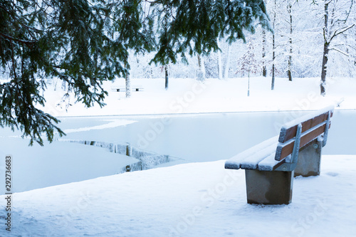 Side view of Empty bench in a snowy park near the lake in Munich, Germany.