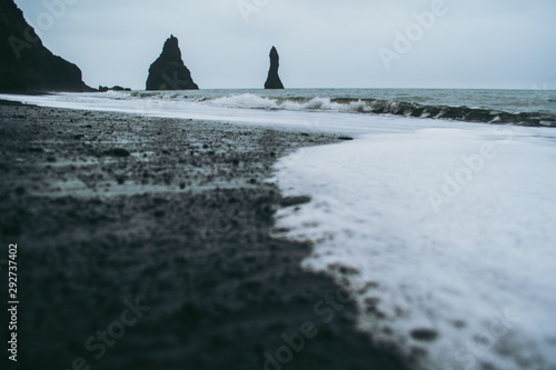 Black sand and white oceanic water on Reynisfjara beach, Iceland © Yurii Zymovin