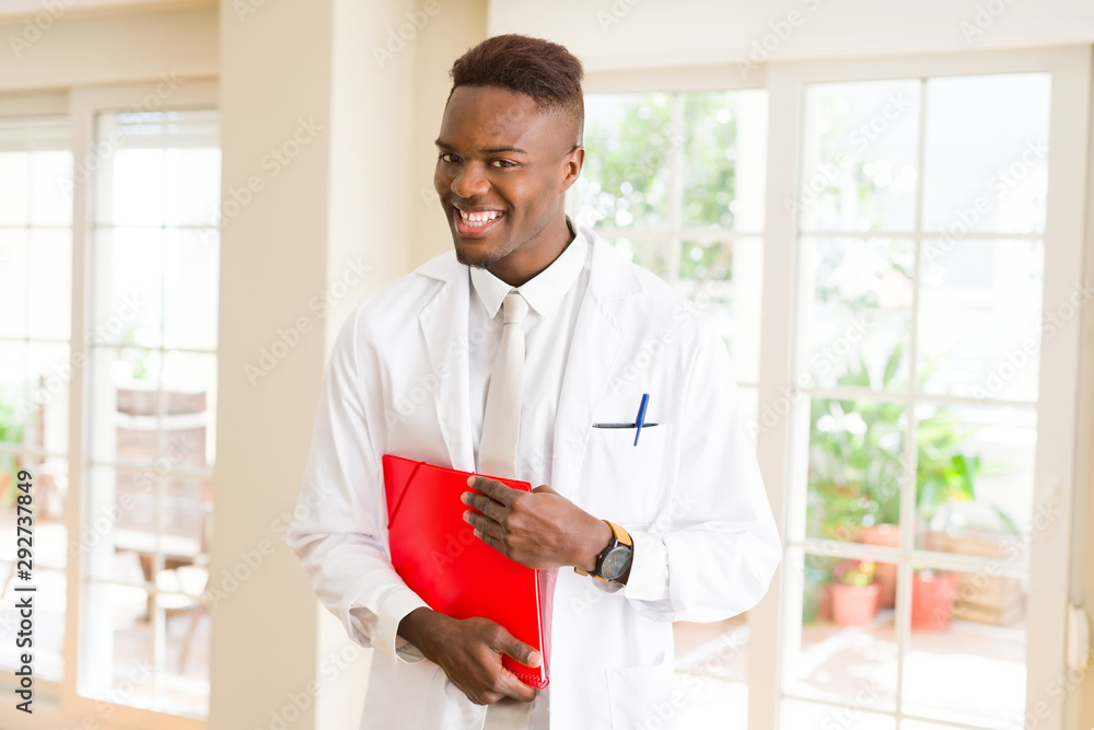 African american doctor man smiling wearing stethoscope and holding a notebook with documents